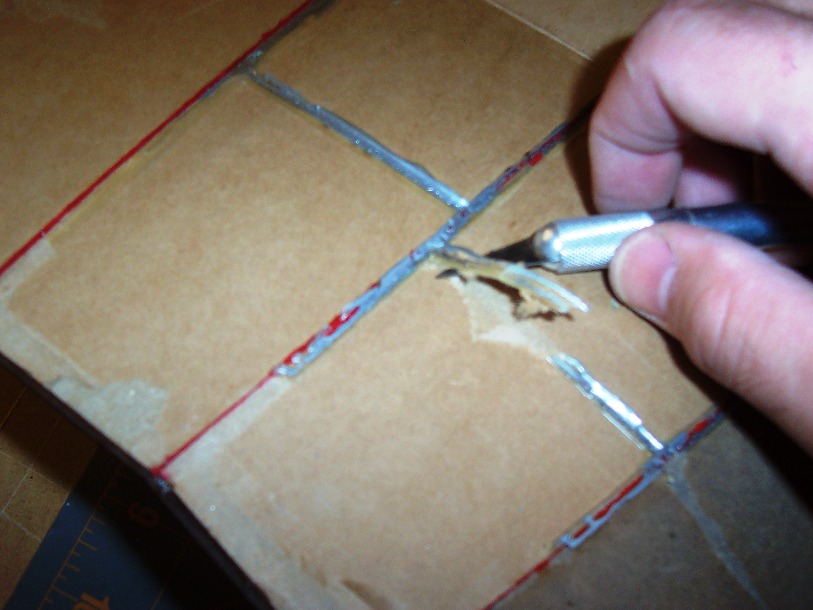 Removing the dried on glue with an X-acto knife